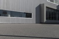 a white metal building with large windows on the outside of it and a fire hydrant at the top of it