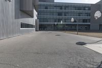 a stop sign sits in the middle of the road outside of an industrial building with glass