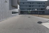 a stop sign sits in the middle of the road outside of an industrial building with glass