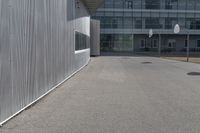 a stop sign sits in the middle of the road outside of an industrial building with glass