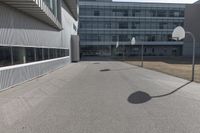 a stop sign sits in the middle of the road outside of an industrial building with glass