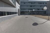 a stop sign sits in the middle of the road outside of an industrial building with glass