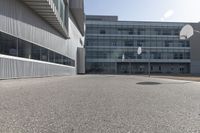 a stop sign sits in the middle of the road outside of an industrial building with glass