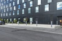 black car parked in front of black and grey building in front of parking spaces and building