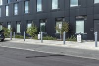 black car parked in front of black and grey building in front of parking spaces and building