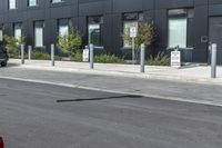 black car parked in front of black and grey building in front of parking spaces and building