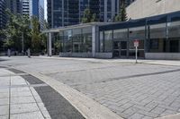 a person sitting at the bench in front of a mall that is empty of people