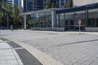 a person sitting at the bench in front of a mall that is empty of people