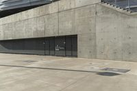 an empty parking garage on a concrete surface with stairs and an iron shuttered door