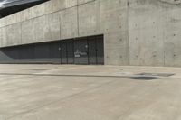 an empty parking garage on a concrete surface with stairs and an iron shuttered door