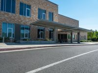 a sidewalk that has a sidewalk sign on it that says green lane park school, in the middle of the street are two buildings with windows and three storys with a sky background