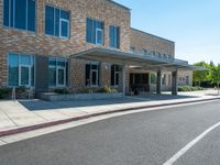 a sidewalk that has a sidewalk sign on it that says green lane park school, in the middle of the street are two buildings with windows and three storys with a sky background