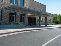 a sidewalk that has a sidewalk sign on it that says green lane park school, in the middle of the street are two buildings with windows and three storys with a sky background