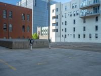 a street with a building near the building in the middle and on the left of which is a parking lot, as shown in this photo