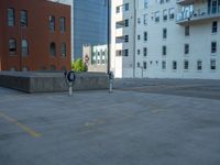 a street with a building near the building in the middle and on the left of which is a parking lot, as shown in this photo