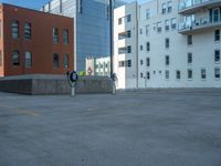 a street with a building near the building in the middle and on the left of which is a parking lot, as shown in this photo