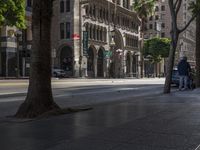 a busy street and curb with two cars parked along it and birds walking along the curb near the road