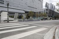 a building with people riding bikes near a street light and fenced in area with tall buildings