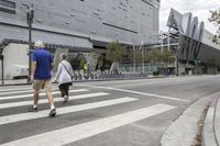 a building with people riding bikes near a street light and fenced in area with tall buildings