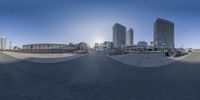 an 360 - view lens of a man in blue shirt on a skateboard in a city