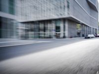 the photo is blurry and shows a street full of people and cars passing by