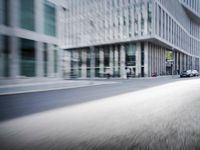 the photo is blurry and shows a street full of people and cars passing by