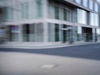 the photo is blurry and shows a street full of people and cars passing by