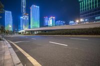 a busy city at night with the traffic passing through it and illuminated high rise buildings