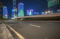 a busy city at night with the traffic passing through it and illuminated high rise buildings