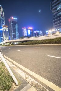 a busy city at night with the traffic passing through it and illuminated high rise buildings