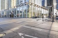 a busy city street with glass buildings in the background and a red light on the corner