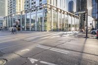 a busy city street with glass buildings in the background and a red light on the corner