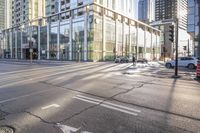 a busy city street with glass buildings in the background and a red light on the corner