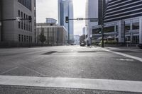 an empty city street filled with lots of traffic, and tall buildings in the background