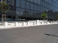 a building that is next to some benches in the street while someone is walking by