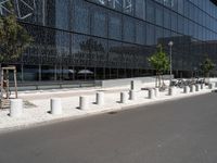 a building that is next to some benches in the street while someone is walking by