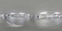 a fish eye lens showing a parking garage full of cars and people walking around it