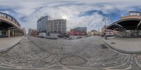 a fish eye view of a busy shopping center area with lots of buildings, cars and bikes