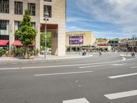 people cross an intersection near tall buildings on a busy street in a city in europe