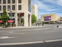 people cross an intersection near tall buildings on a busy street in a city in europe