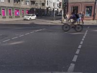 the traffic light turns at a busy street corner in europe by an old building with pink painted signs on it