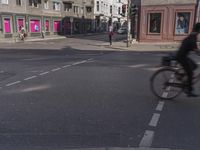 the traffic light turns at a busy street corner in europe by an old building with pink painted signs on it