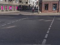 the traffic light turns at a busy street corner in europe by an old building with pink painted signs on it