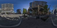 a curved panorama photo taken in a fish eye lens showing buildings and cars on a busy street