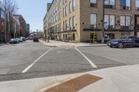 a couple of cars driving down a street next to buildings and a staircase way on either side of it