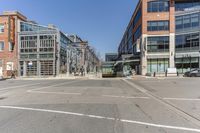 a street with vehicles parked in front of tall buildings in the background is a large brick building