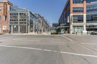 a street with vehicles parked in front of tall buildings in the background is a large brick building