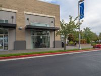 a paved street outside a business with cars and flags in the foregrounded photo