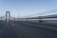 a view of traffic driving on a freeway over an arch of a bridge across the river