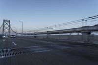 a view of traffic driving on a freeway over an arch of a bridge across the river